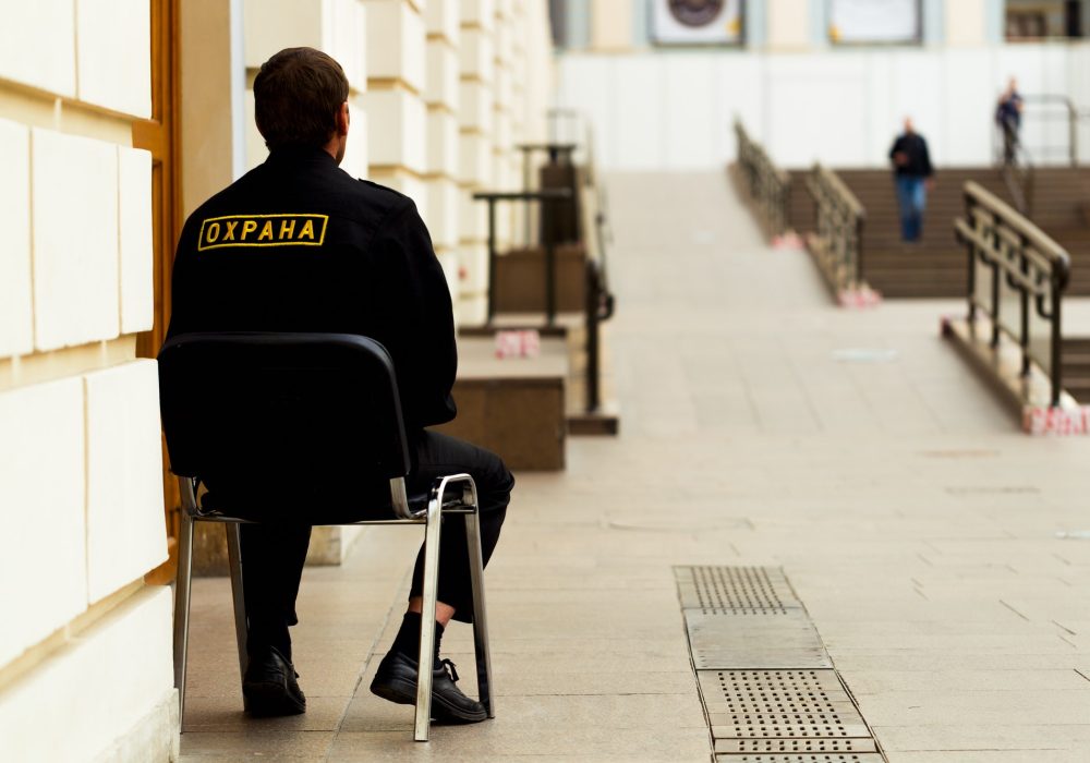Security guard sitting on a chair at the entrance to the indoor
